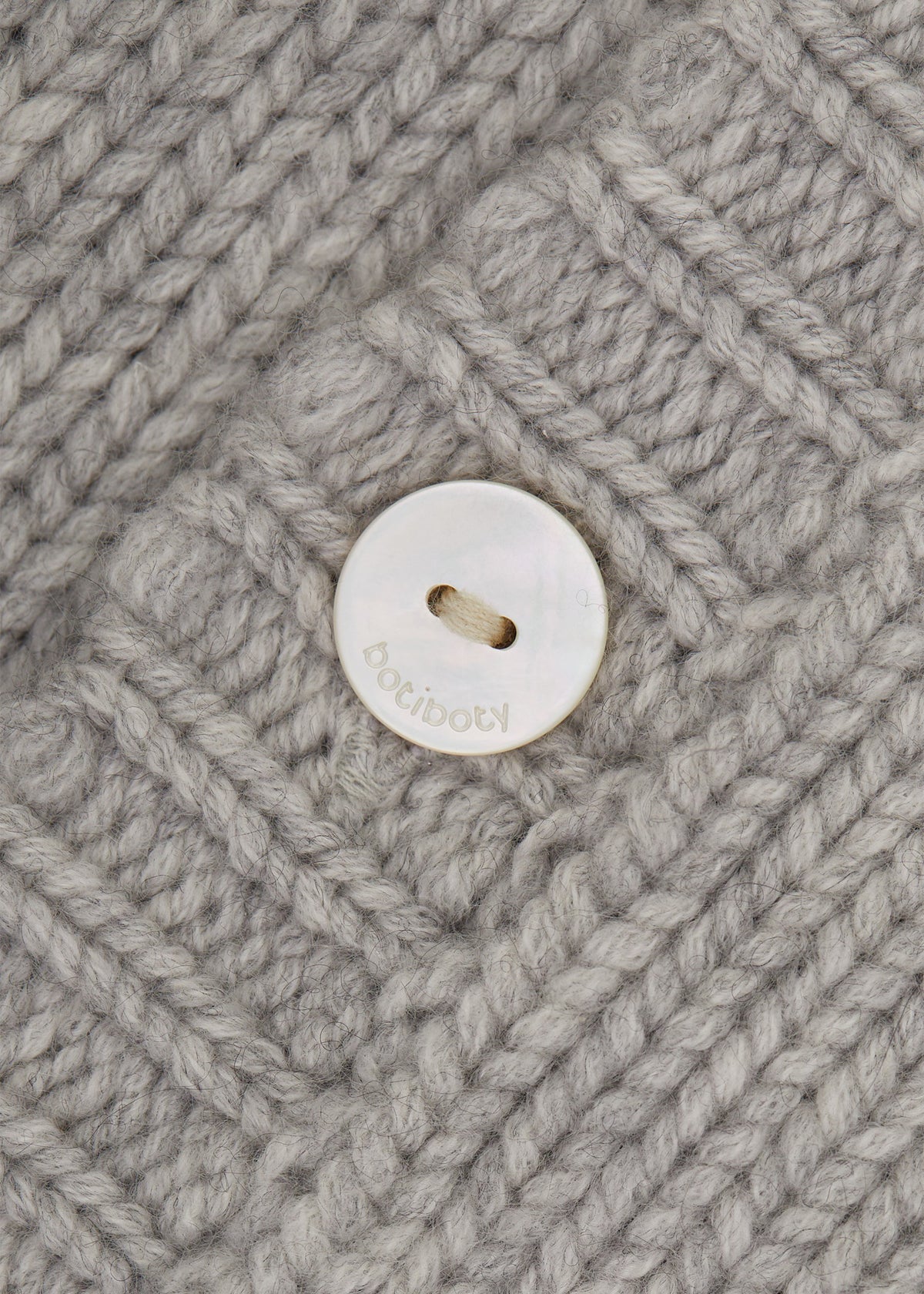 Détail du bouton en nacre gravé du nid d’ange bébé BOTIBOTY
