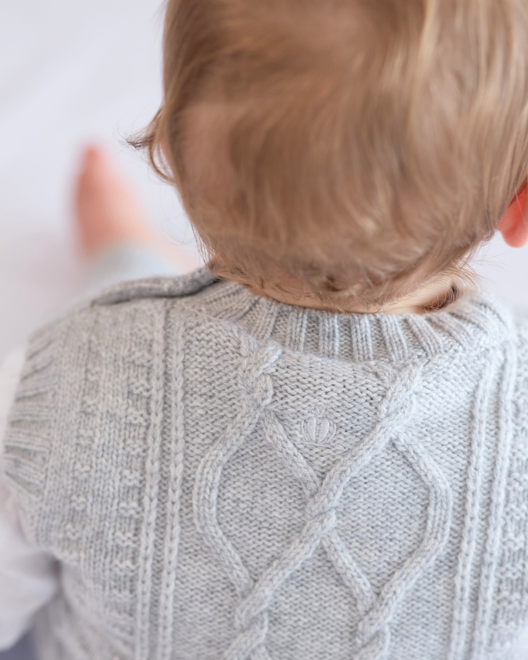 Vue de dos du pull torsadé sans manches bébé en cachemire gris